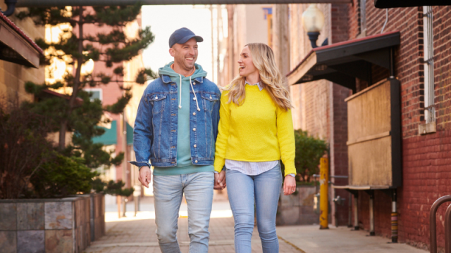 A couple holding hands and walking down an alley