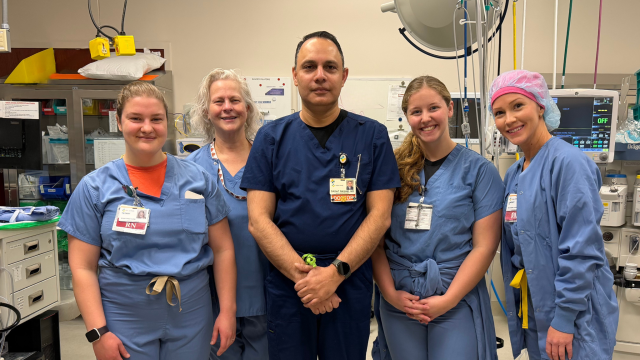 A doctor and nurses standing together in a operating room