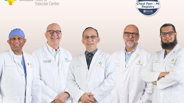 A group of doctors in white lab coats standing shoulder to shoulder