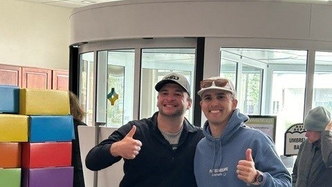 Two men giving the thumbs up in the hospital lobby