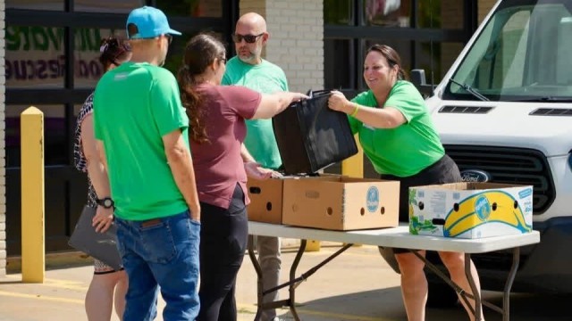 Goshen Health employee standing at a table while handing out free meals