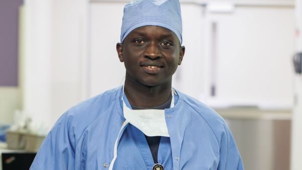 Nurse in scrubs holding an award