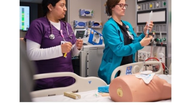 Two nurses practicing on a dummy