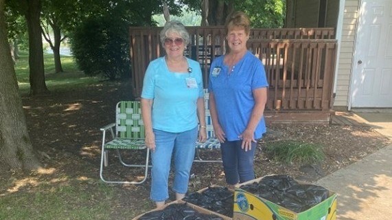 Two women standing in front of boxes