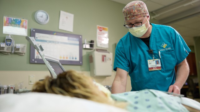 Nurse assisting a patient lying in bed