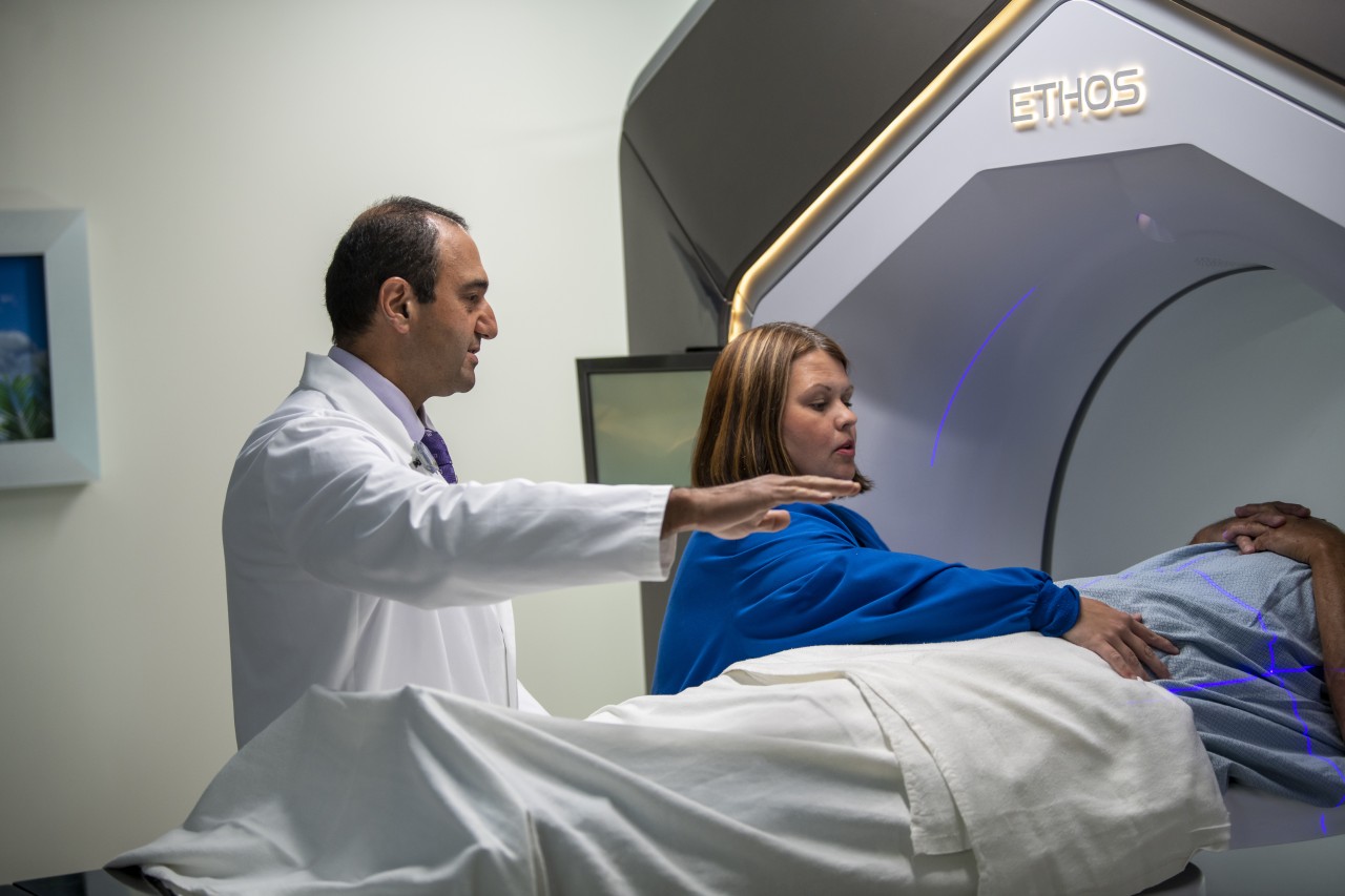 Doctor and nurse helping a patient, who is on a bed, get set up for a test