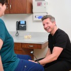 Doctor smiling at patient while examining her knee