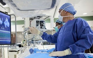 Doctors performing a medical procedure on a patient who is laying on a bed