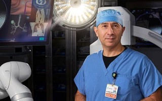Doctor standing in front of a robotic medical machine