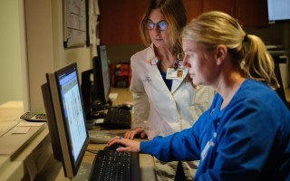 Two nurses reviewing information on a computer screen