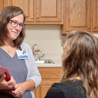 Doctor standing while talking with a patient