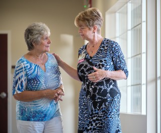 Doctor standing with patient hand on shoulder