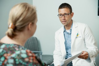 Doctor showing a patient a paper while sitting in an office