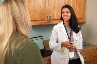Doctor smiling while talking to patient in an exam room