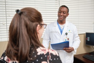 Doctor with folder in his hand talking to a patient