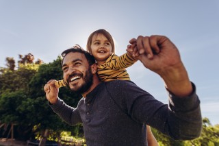 Father smiling with his child on his shoulders