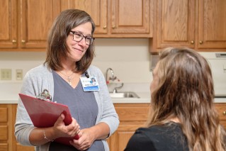 Doctor standing while talking with a patient