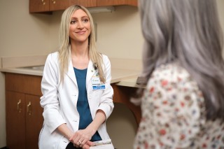 Doctor and patient sitting across from each other while having a conversation in an exam room