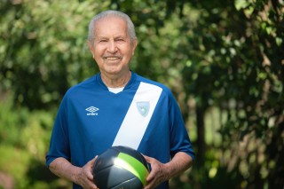 Man smiling while holding a soccer ball