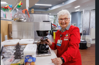 Older woman holding a coffee pot