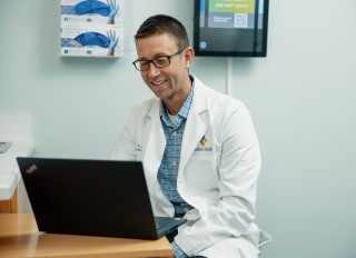 Doctor sitting at a desk looking at his computer