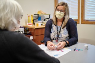 Two women in masks discussing diabetic supplies