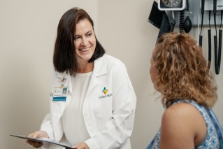 Doctor smiling at patient while sitting in an exam room