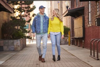 Couple holding hands and walking down an alley between buildings