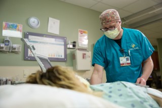 Nurse standing next to a patient in bed