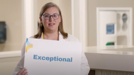 Woman holding a sign that says "Exceptional"