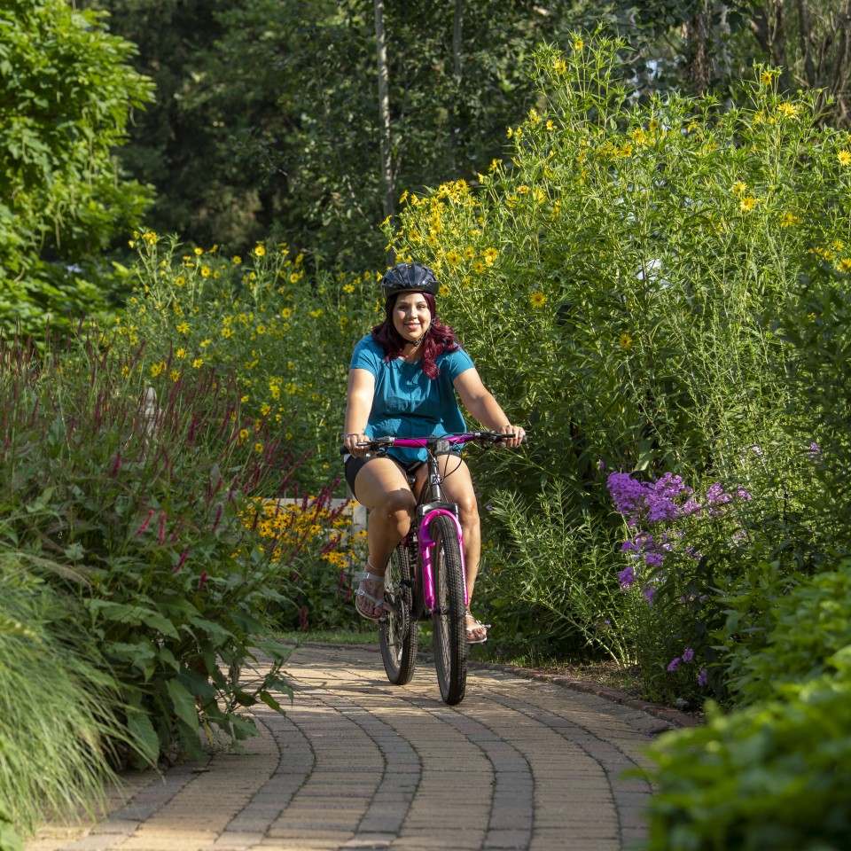 Woman riding a bike on a trail in the woods