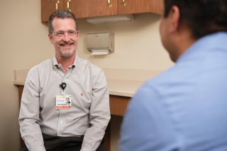 Doctor smiling at patient sitting in an exam room